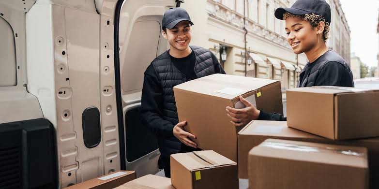 Delivery team loading boxes into van